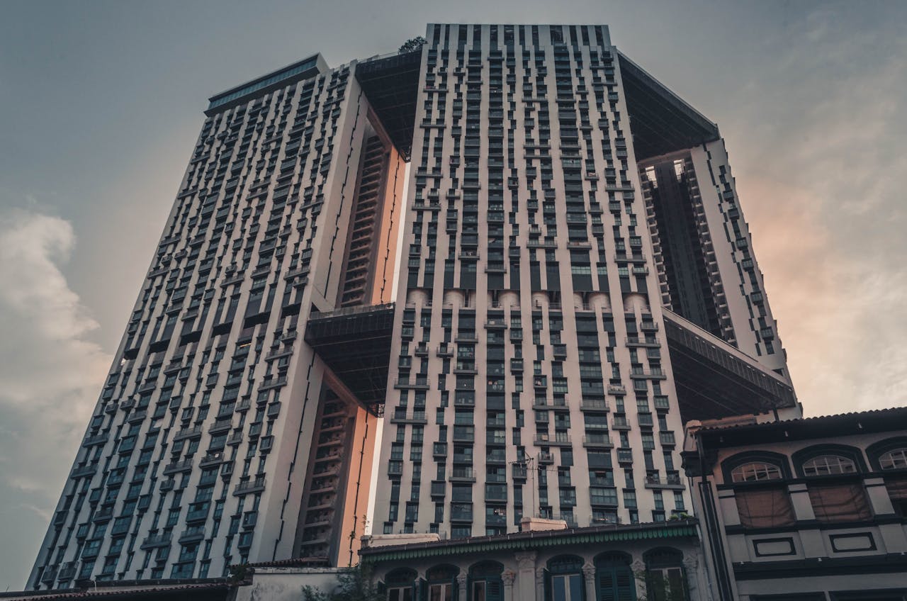 Low-angle view of a modern skyscraper in Singapore at dusk, showcasing urban architectural design.